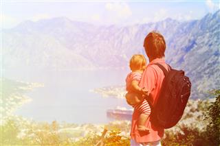 Father with little daughter travel in mountains