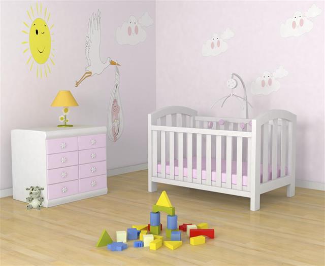 Baby's room with decor, crib, toys and a dresser with lamp
