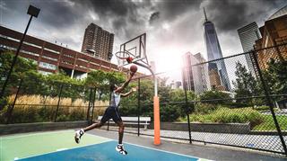 Street basketball player doing a slam dunk