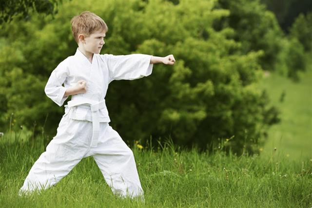 Young boy practising karate outdoors