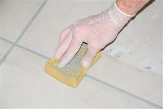 Tiler smoothing tile joints with a sponge