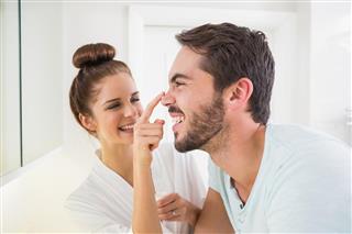 Young woman touching her boyfriends nose