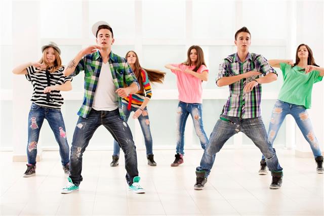 Team of teenage dancers exercising hip hop dance