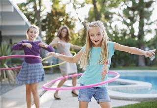 Mother and daughters hula hooping outdoors