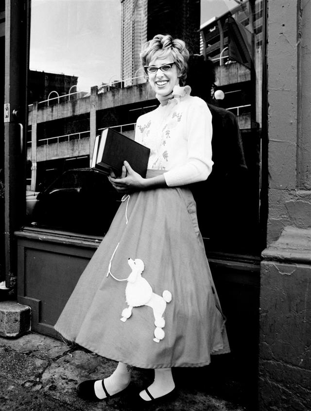 Young Woman Wearing Poodle Skirt and Holding Books