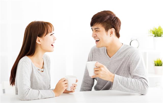 Couple drinking coffee In living room