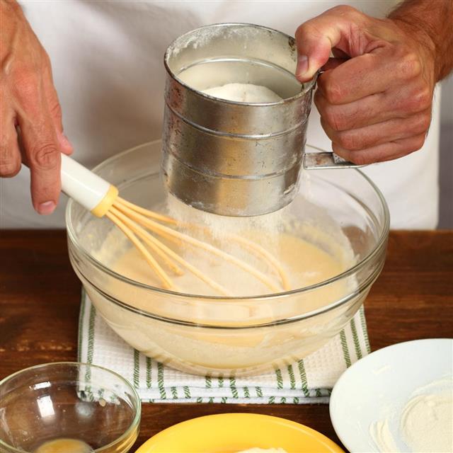 Sifting flour into batter