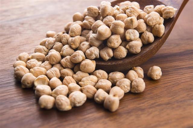 Dried white chickpeas on the wooden spoon