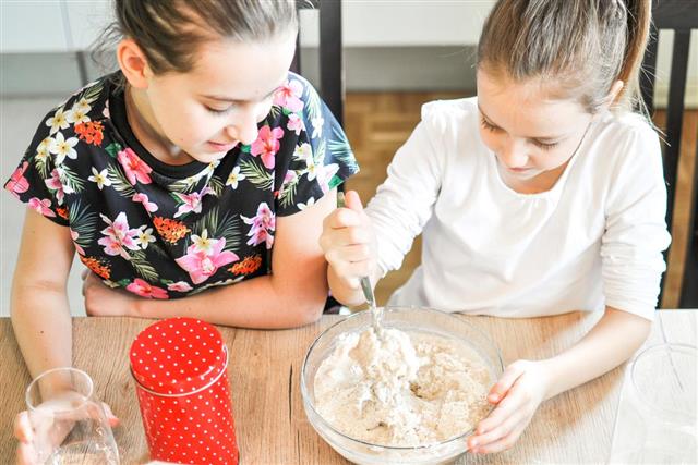 Two girls making dough