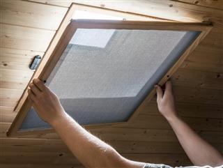 Installing homemade mosquito net on window on ceiling