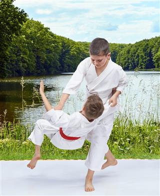 Throw judo athletes are doing on the background of nature