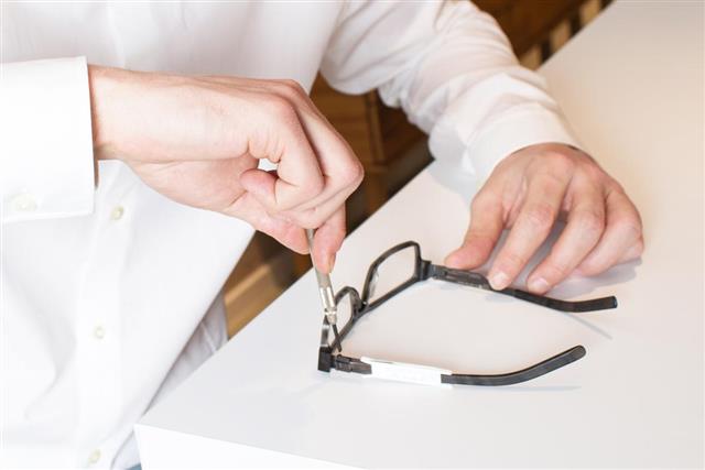 Optician repairs eyeglasses