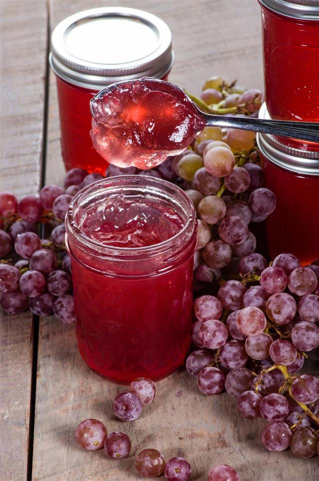 Jars of jelly and grapes with spoon