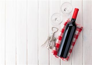 Red wine bottle, glasses and corkscrew