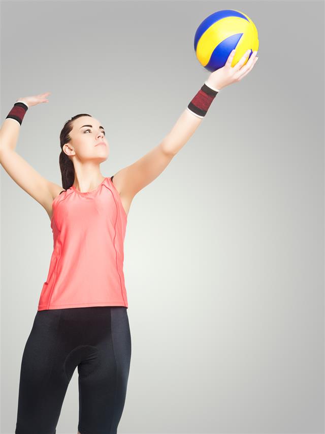 Professional Female Volleyball Athlete Serving Ball