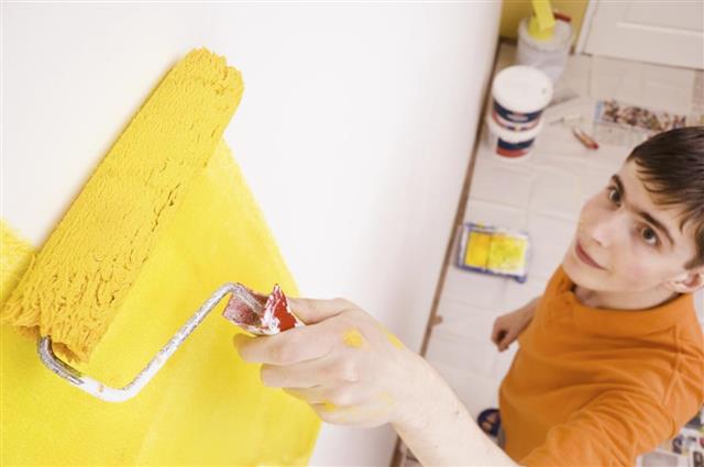 Young man paint the wall in a new house