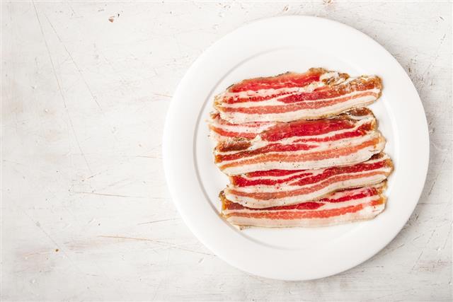 Streaky bacon on the white scratched table top view