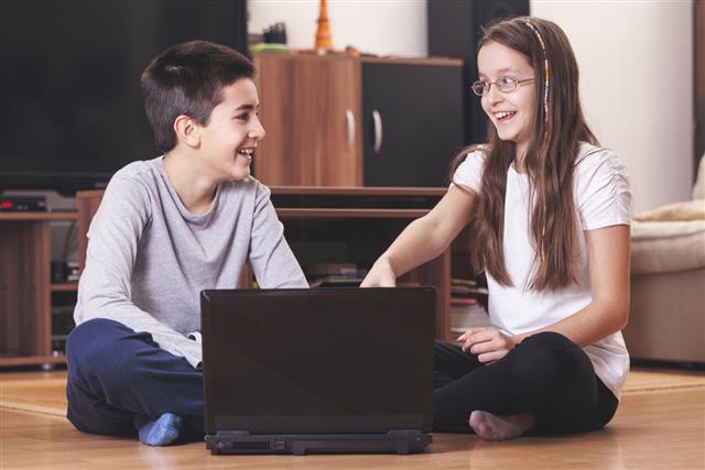 Boy and girl with laptop PC having fun