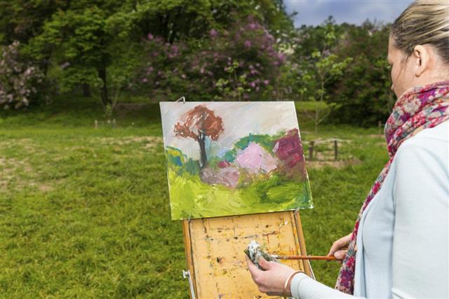 female painter working in  forest