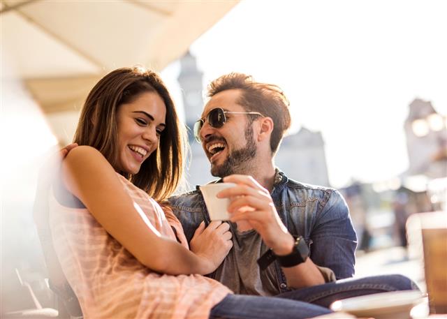 Cheerful couple laughing while enjoying a day at a cafe.