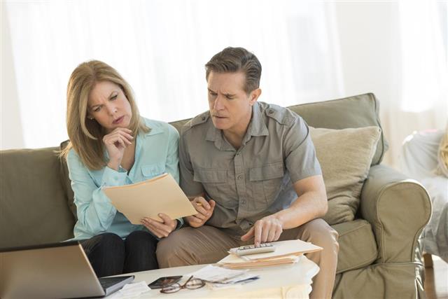 Mature couple calculating home finances on sofa