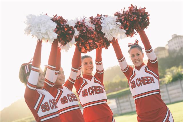 Group of Cheerleaders with Raised Pom-pom