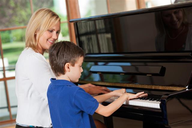 young boy getting piano lessons
