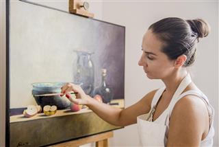 Woman painting on canvas for fun at home