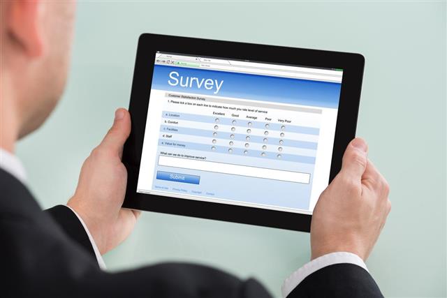 Businessman Looking At Online Survey Form On Digital Tablet