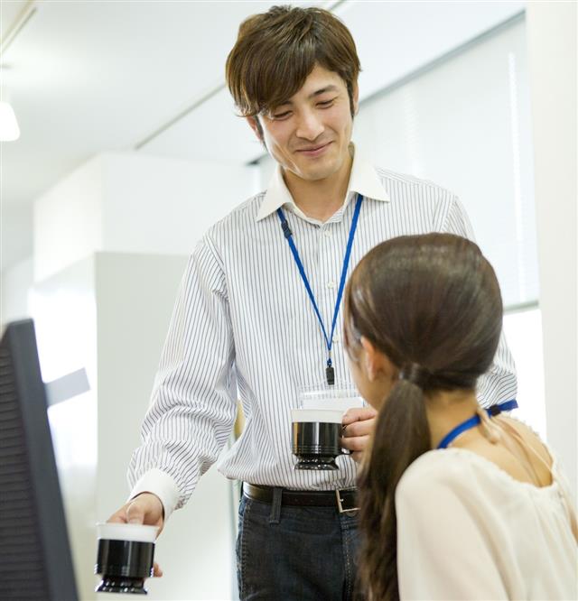 Man serving coffee to colleague of company