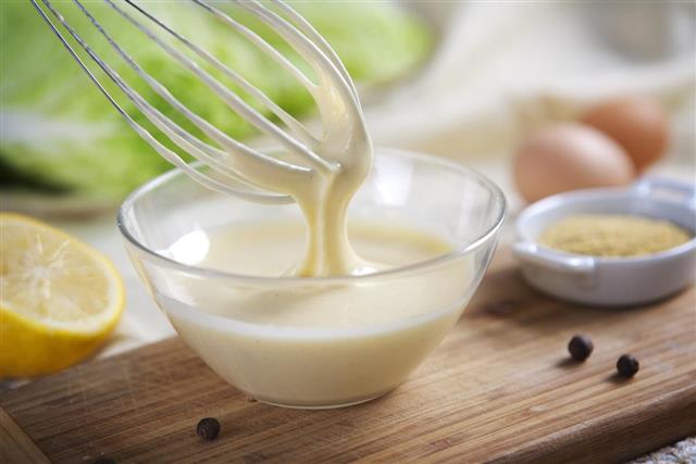 mayonnaise being whipped in a glass bowl