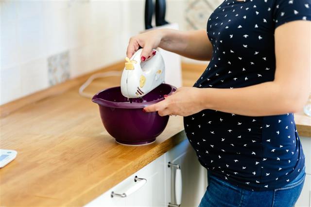 Pregnant woman making cake