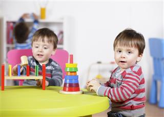 Identical Twin Boys Playing With Multi-coloured Toys