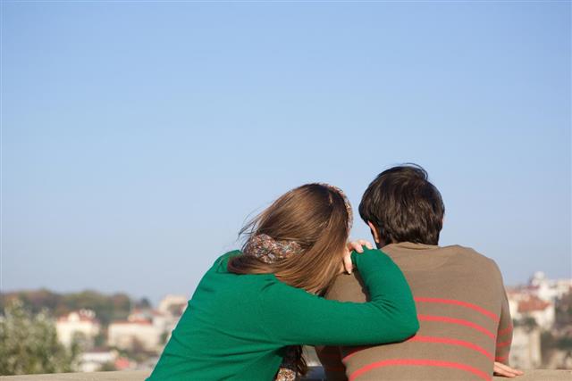 Rear view of a young woman leaning on man's shoulder