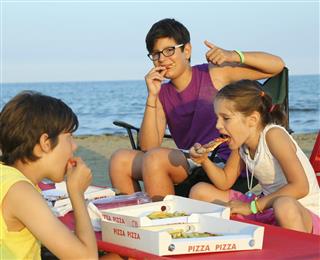 Happy three brothers eating pizza