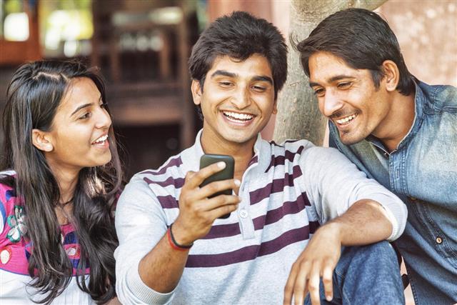 Group of Young Indian Friends Looking at Smart Phone