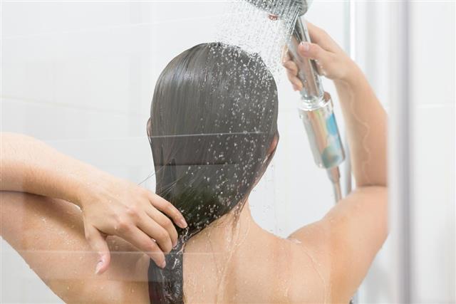 Girl washing hair under shower