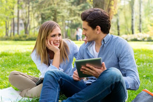 Young couple with tablet computer in the park