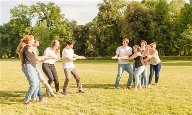 Friends playing Tug of war in a park