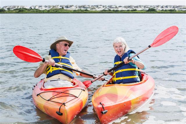 Senior couple having fun kayaking together