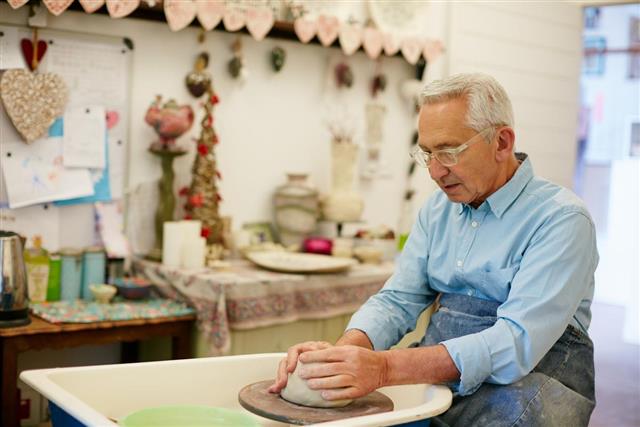 Senior man making object