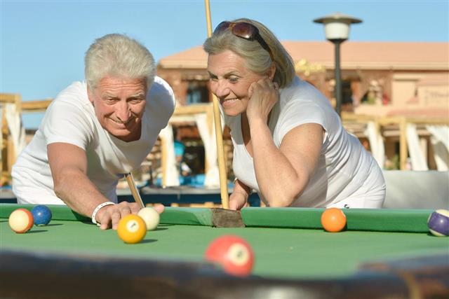 Old couple playing billiard