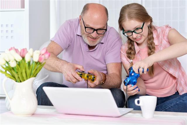 Grandfather and granddaughter playing video games