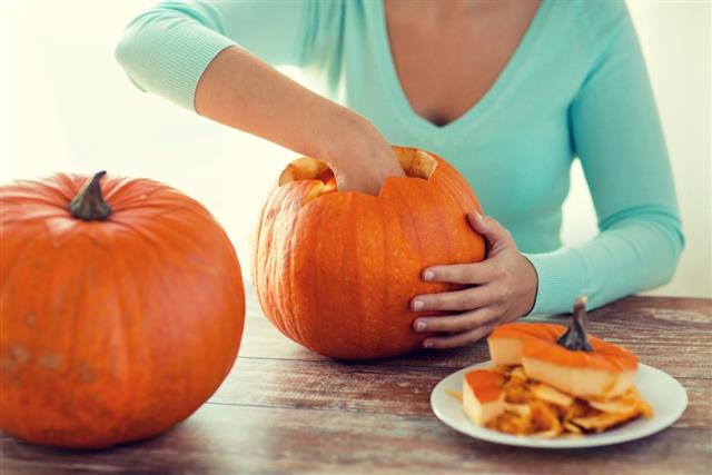 Close up of woman with pumpkins at home