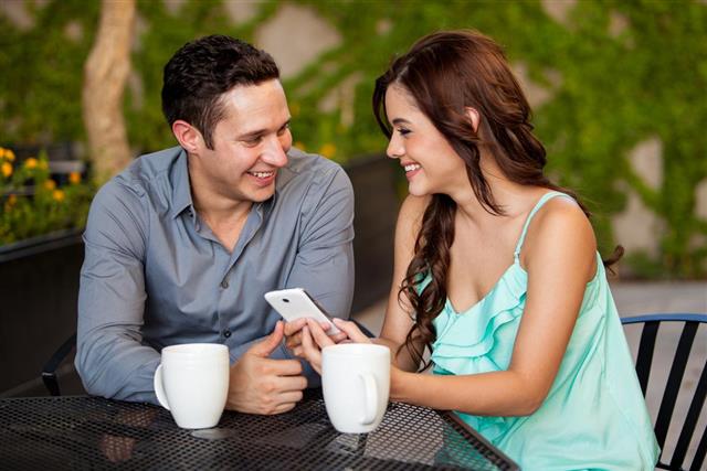 Couple having coffee and looking at a smartphone