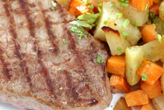 Grilled steak with cubed potatoes and carrots