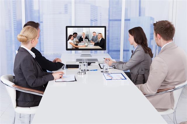Business People In Video Conference At Table