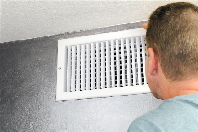 Man Looking in an Air Vent