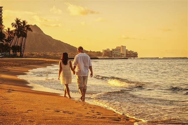 Happy Couple Walking on Waikiki Beach at Sunrise