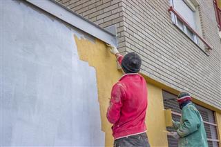 builder workers plastering exterior wall